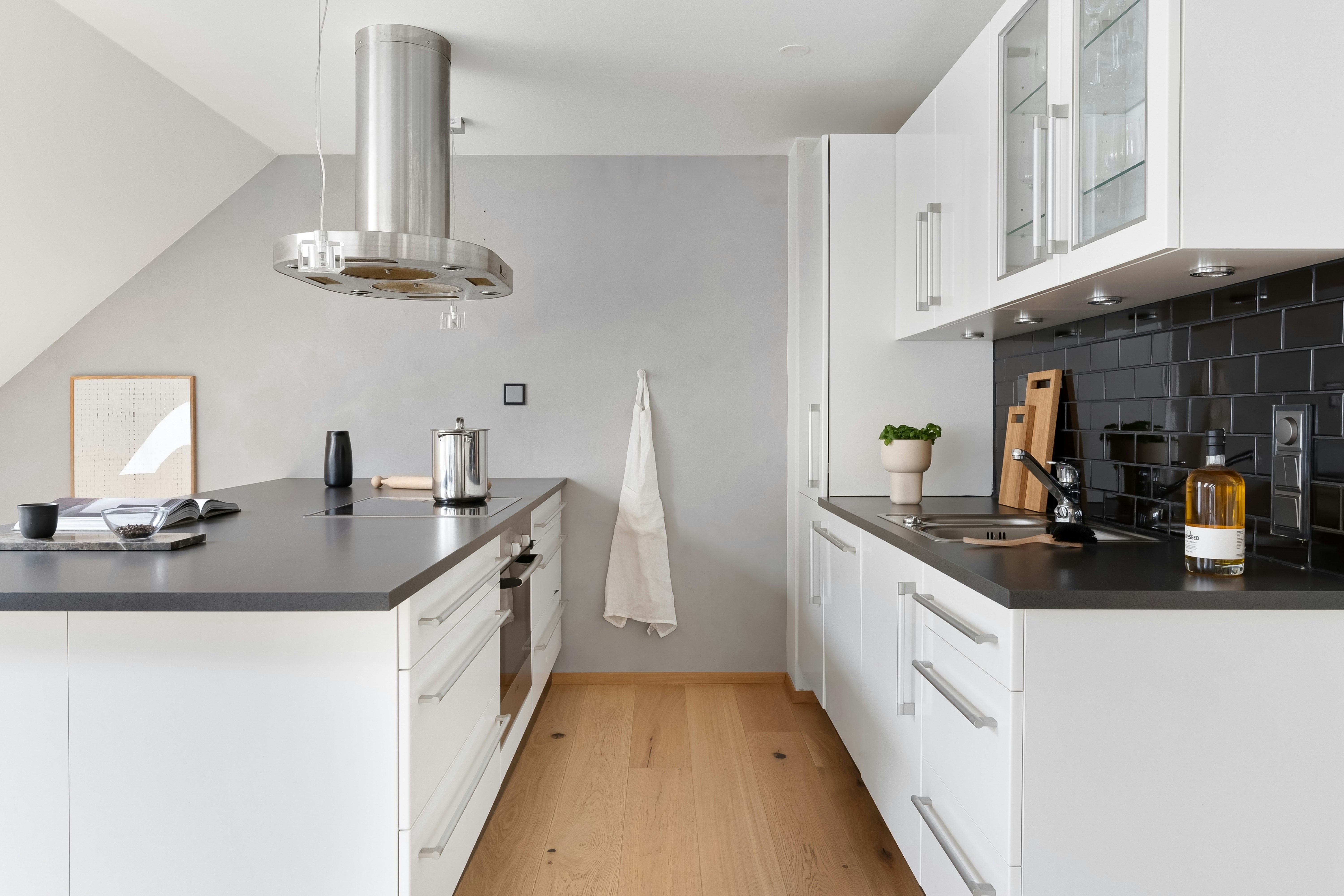 A kitchen with white cabinets and black counter tops